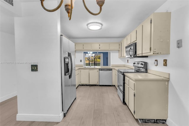 kitchen featuring visible vents, cream cabinetry, light wood-style floors, appliances with stainless steel finishes, and light countertops