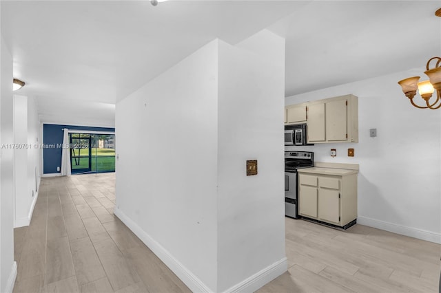 interior space with baseboards, a notable chandelier, and light wood finished floors