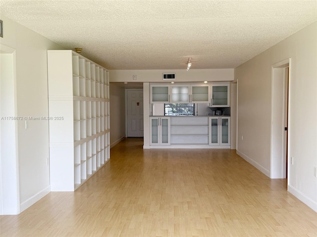1504 S Whitehall Dr Unit 206, Davie, FL 33324 - unfurnished living room featuring light wood finished floors and a textured ceiling