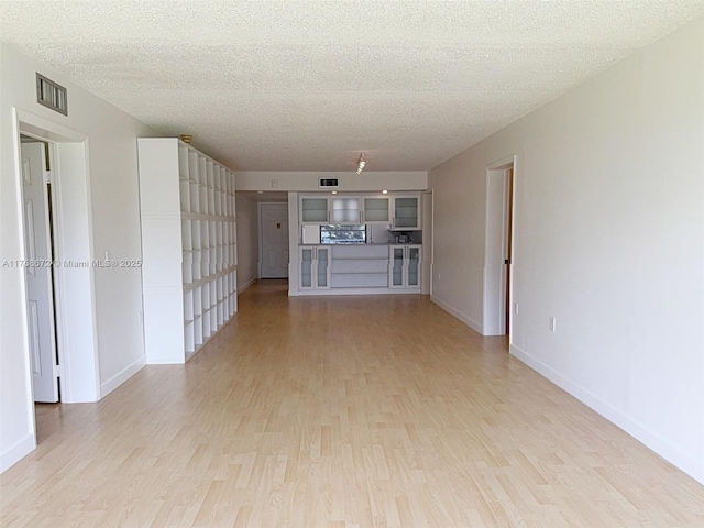 1504 S Whitehall Dr Unit 206, Davie, FL 33324 - unfurnished living room with light wood-type flooring and a textured ceiling