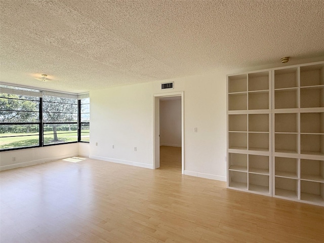 1504 S Whitehall Dr Unit 206, Davie, FL 33324 - spare room with a textured ceiling, light wood finished floors, a smoke detector, and built in features