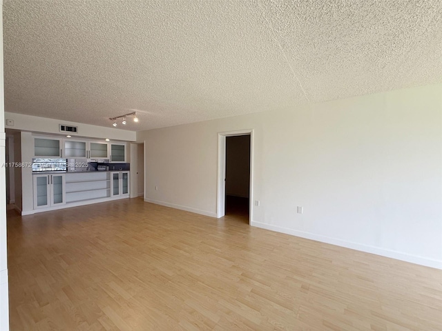 1504 S Whitehall Dr Unit 206, Davie, FL 33324 - unfurnished living room with a textured ceiling, light wood finished floors, and track lighting
