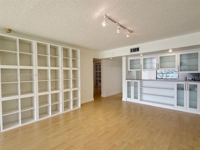 1504 S Whitehall Dr Unit 206, Davie, FL 33324 - spare room featuring a textured ceiling, rail lighting, light wood finished floors, and a smoke detector