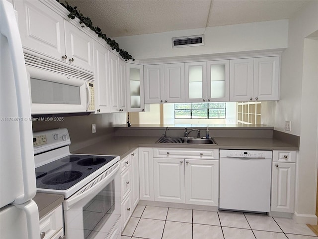 1504 S Whitehall Dr Unit 206, Davie, FL 33324 - kitchen with white appliances, light tile patterned floors, white cabinetry, glass insert cabinets, and dark countertops