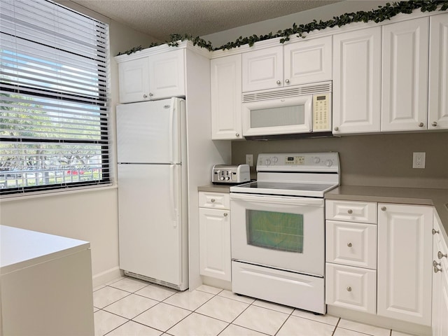1504 S Whitehall Dr Unit 206, Davie, FL 33324 - kitchen with white appliances, light tile patterned floors, white cabinets, and a textured ceiling