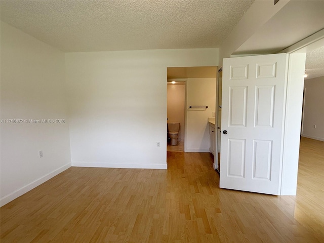 1504 S Whitehall Dr Unit 206, Davie, FL 33324 - unfurnished bedroom featuring light wood-style floors, a textured ceiling, and ensuite bathroom