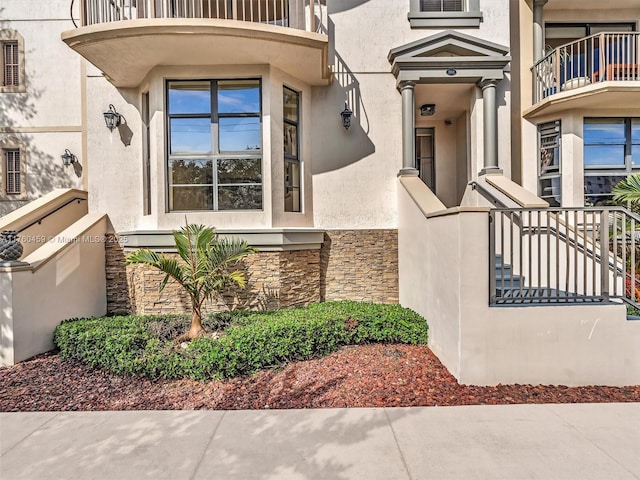 doorway to property featuring stone siding and stucco siding