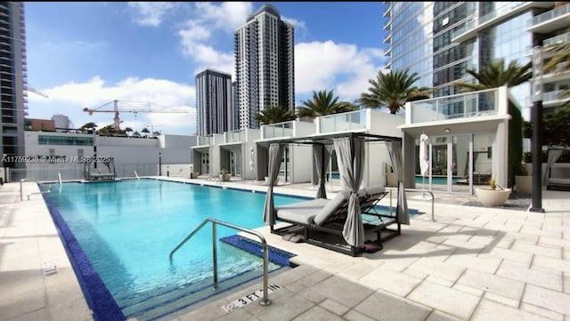 pool with a view of city and a patio area