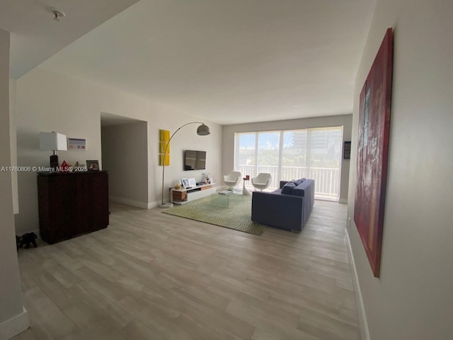 living area with light wood-style floors and baseboards