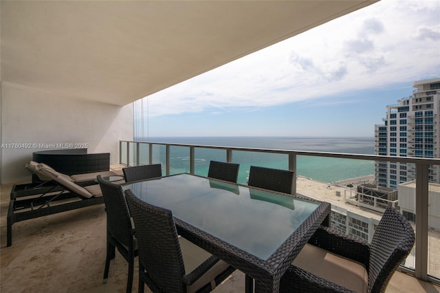 balcony with a water view and outdoor dining space