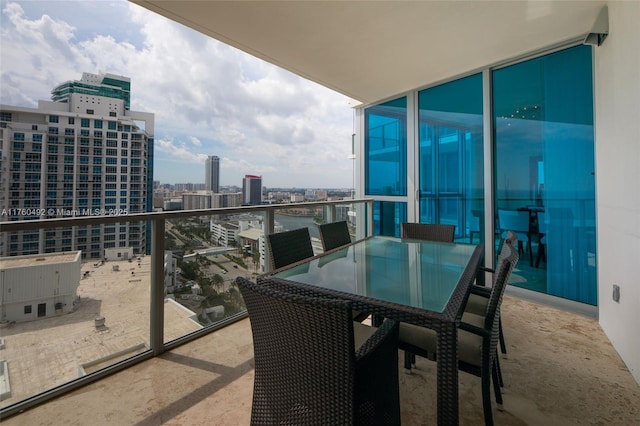 balcony with a view of city and outdoor dining space