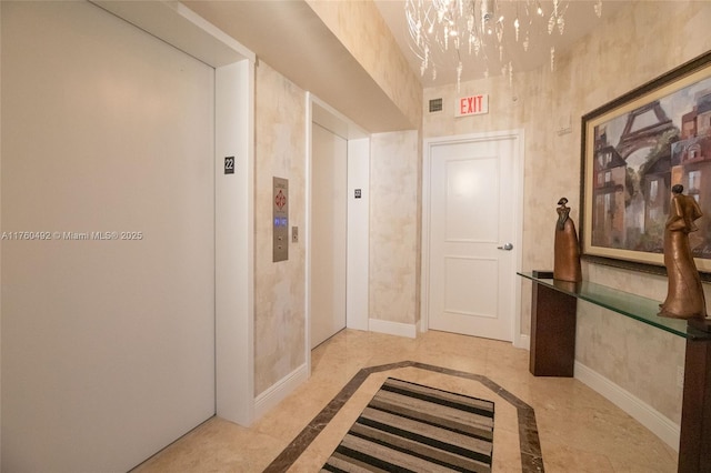 corridor featuring baseboards and elevator