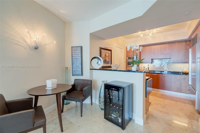 kitchen featuring beverage cooler, backsplash, crown molding, and dark countertops