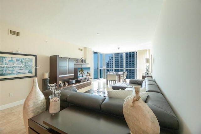 living room with visible vents, baseboards, and expansive windows