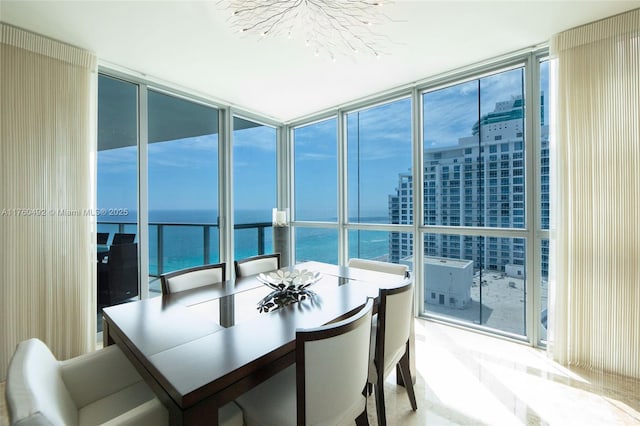 sunroom featuring a water view