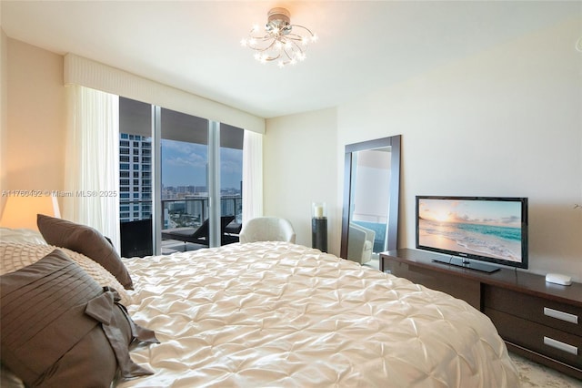 bedroom with access to exterior and an inviting chandelier