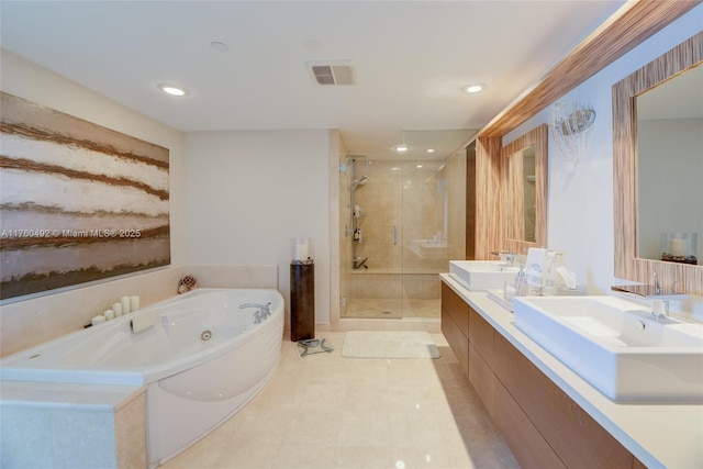 full bathroom featuring a sink, a tub with jets, a stall shower, and double vanity