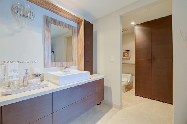 bathroom with toilet, vanity, and baseboards