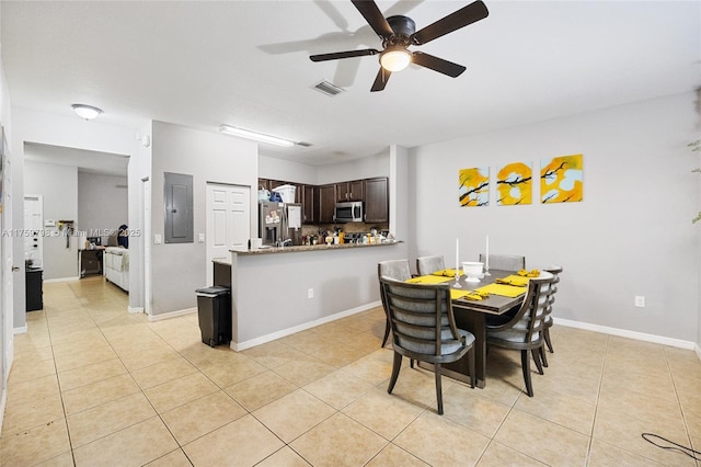 dining space with a ceiling fan, baseboards, light tile patterned floors, visible vents, and electric panel