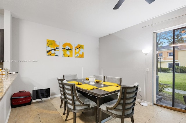 dining room featuring baseboards, a ceiling fan, and light tile patterned floors