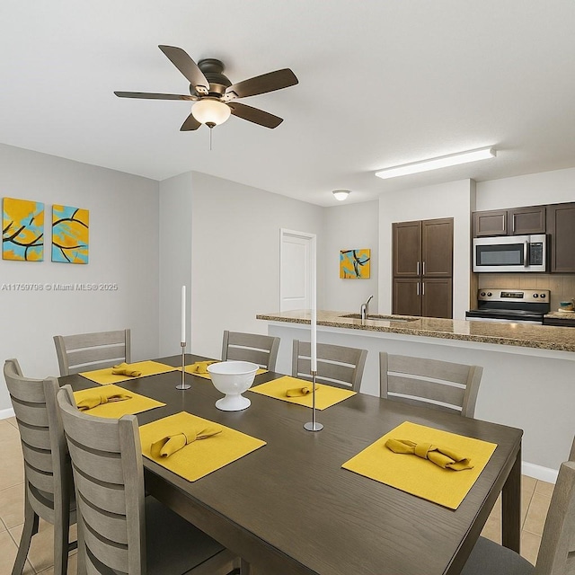 dining area featuring a ceiling fan, baseboards, and light tile patterned floors