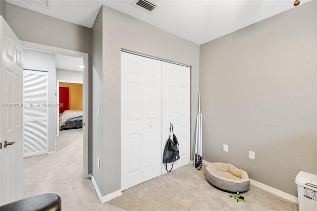 interior space featuring baseboards, light carpet, a closet, and visible vents