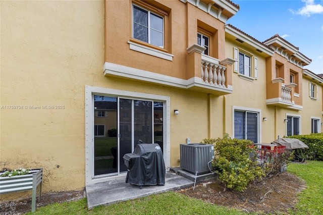 back of property featuring stucco siding, a balcony, and cooling unit