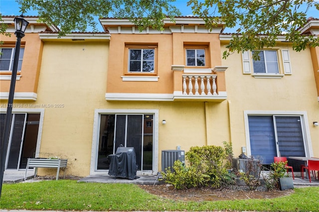 back of property featuring central AC and stucco siding