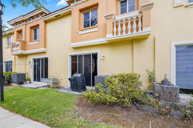 rear view of house featuring stucco siding and cooling unit