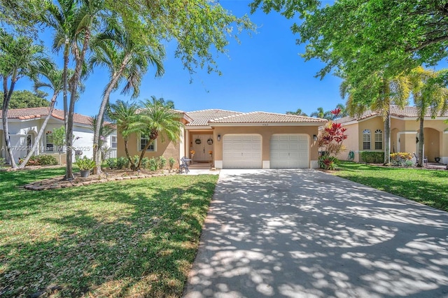 view of front of house with a front lawn, concrete driveway, a tile roof, stucco siding, and a garage