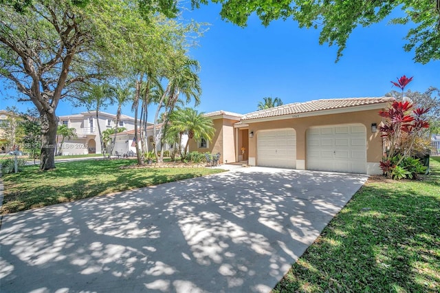 view of front of home featuring a front lawn, a tiled roof, concrete driveway, stucco siding, and an attached garage