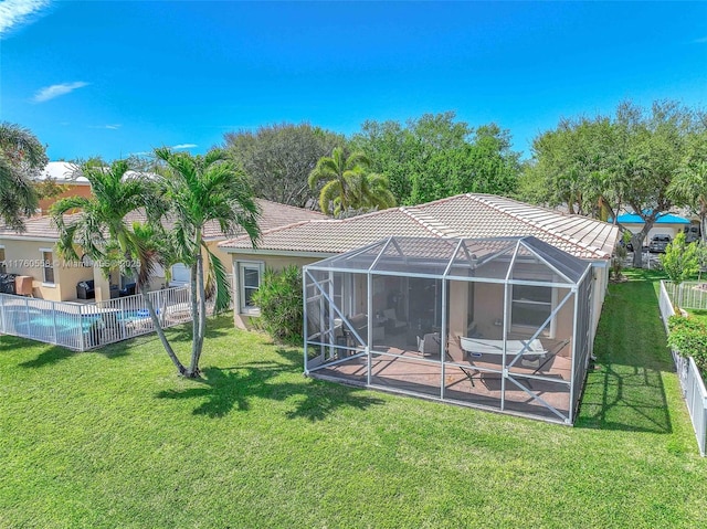 back of house featuring a lawn, a tile roof, a patio, fence, and glass enclosure