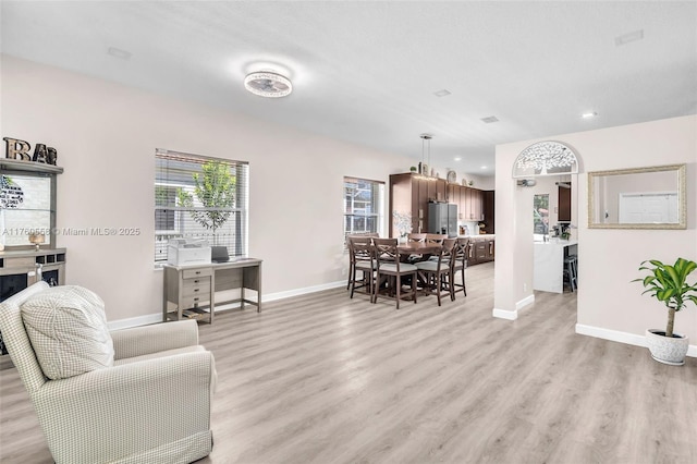 living area with light wood-style floors and baseboards