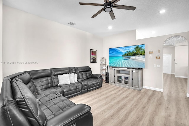 living area with a ceiling fan, visible vents, baseboards, a textured ceiling, and light wood-type flooring