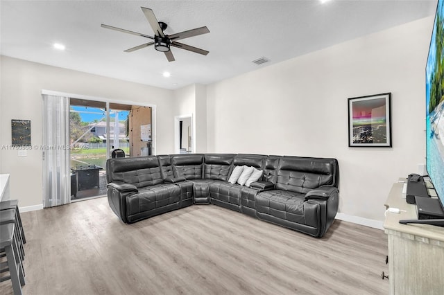 living area featuring visible vents, a ceiling fan, baseboards, and wood finished floors