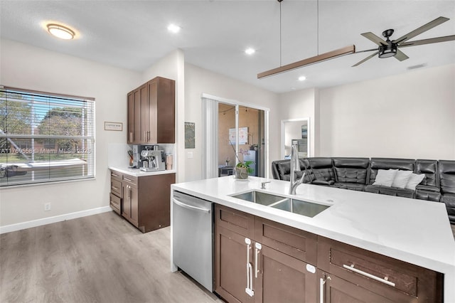 kitchen featuring visible vents, light wood-type flooring, a sink, stainless steel dishwasher, and open floor plan