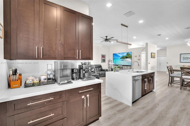 kitchen with visible vents, a sink, open floor plan, light countertops, and dishwasher