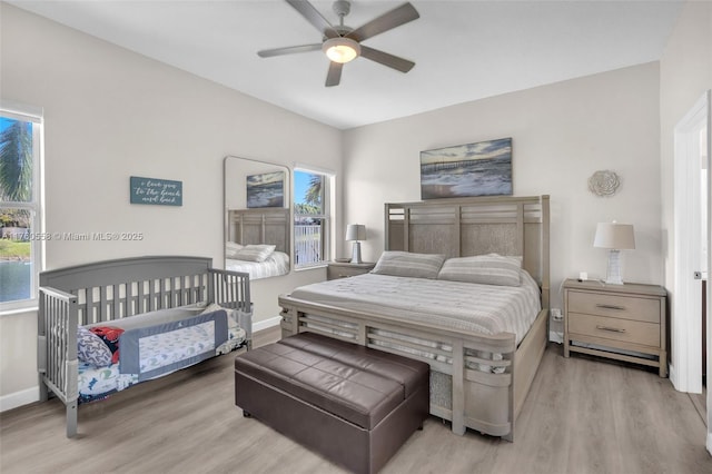 bedroom featuring ceiling fan, baseboards, and wood finished floors