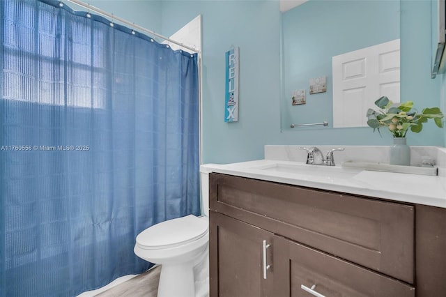 full bath featuring vanity, a shower with shower curtain, and toilet