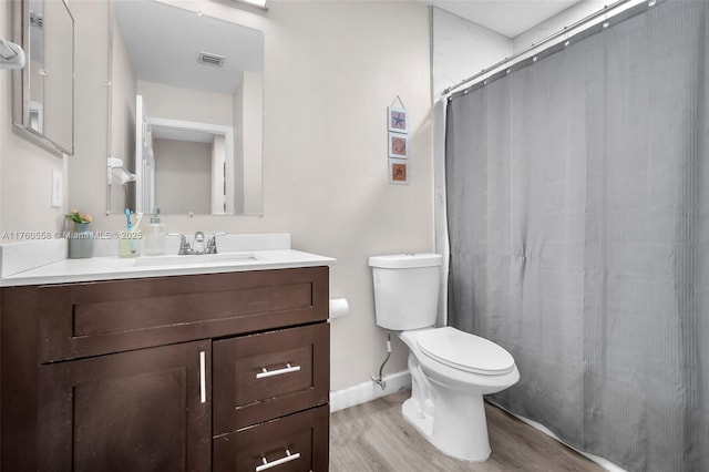 full bathroom featuring vanity, a shower with curtain, wood finished floors, visible vents, and toilet