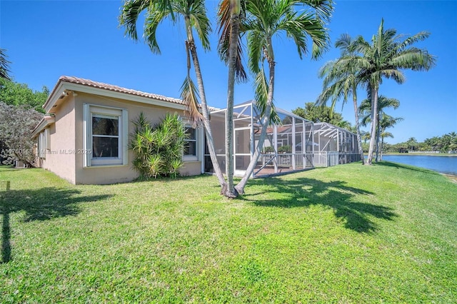 view of yard featuring a lanai and a water view