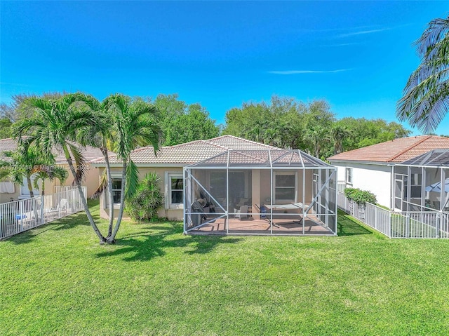 back of property with glass enclosure, a fenced backyard, stucco siding, and a tile roof