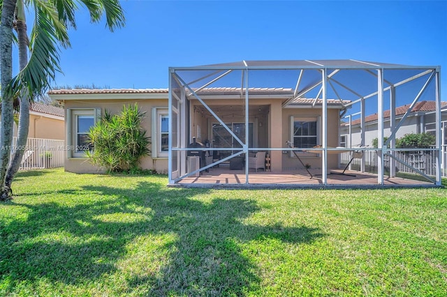 rear view of property featuring a lanai, stucco siding, a patio, and fence