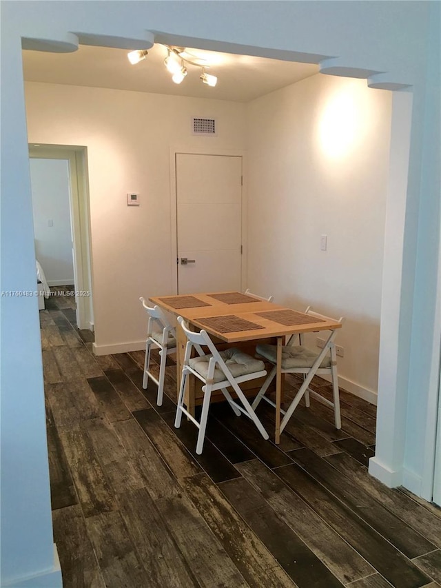 dining space featuring visible vents, baseboards, and dark wood-style floors