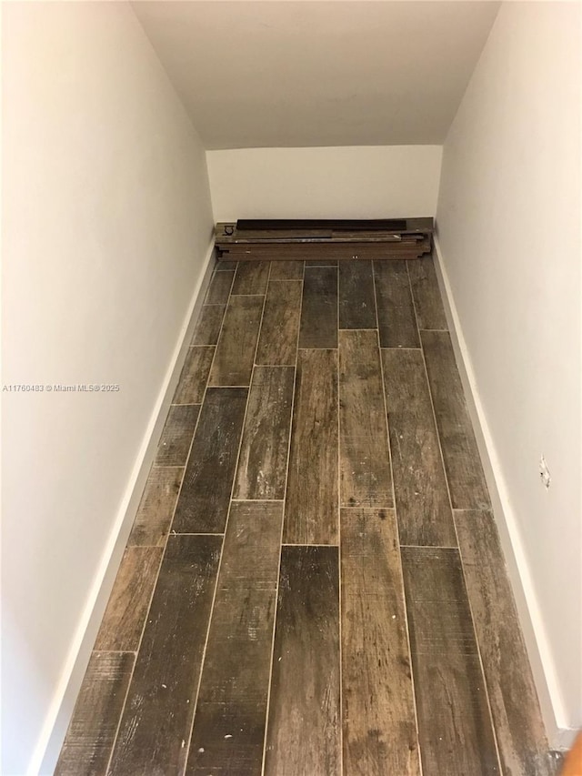 interior space featuring baseboards and wood finished floors