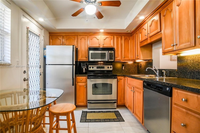 kitchen with decorative backsplash, brown cabinetry, appliances with stainless steel finishes, and a sink