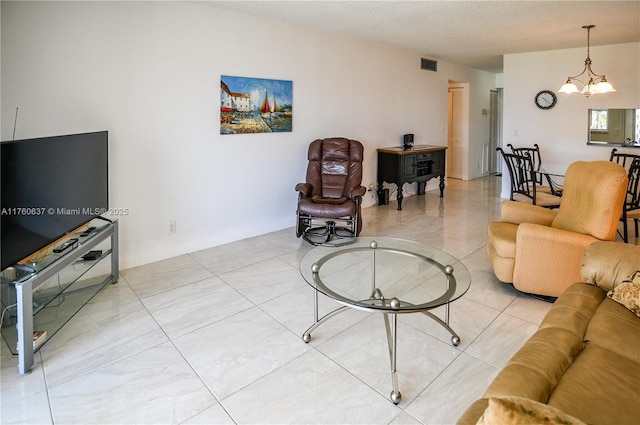 living area with visible vents, a notable chandelier, and a textured ceiling