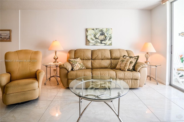 living room featuring baseboards, marble finish floor, and a textured ceiling