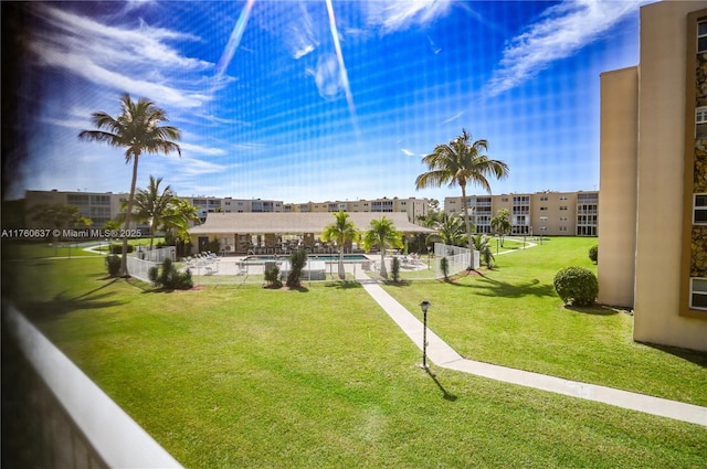 surrounding community featuring a swimming pool, a patio area, and a lawn