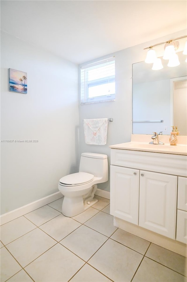 half bath with baseboards, toilet, vanity, and tile patterned flooring